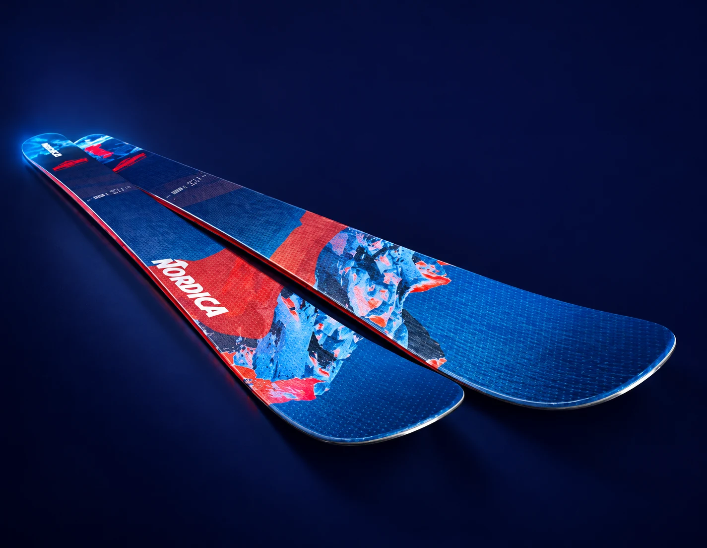 Приподнятые носки лыж Nordica Enforcer на тёмном фоне