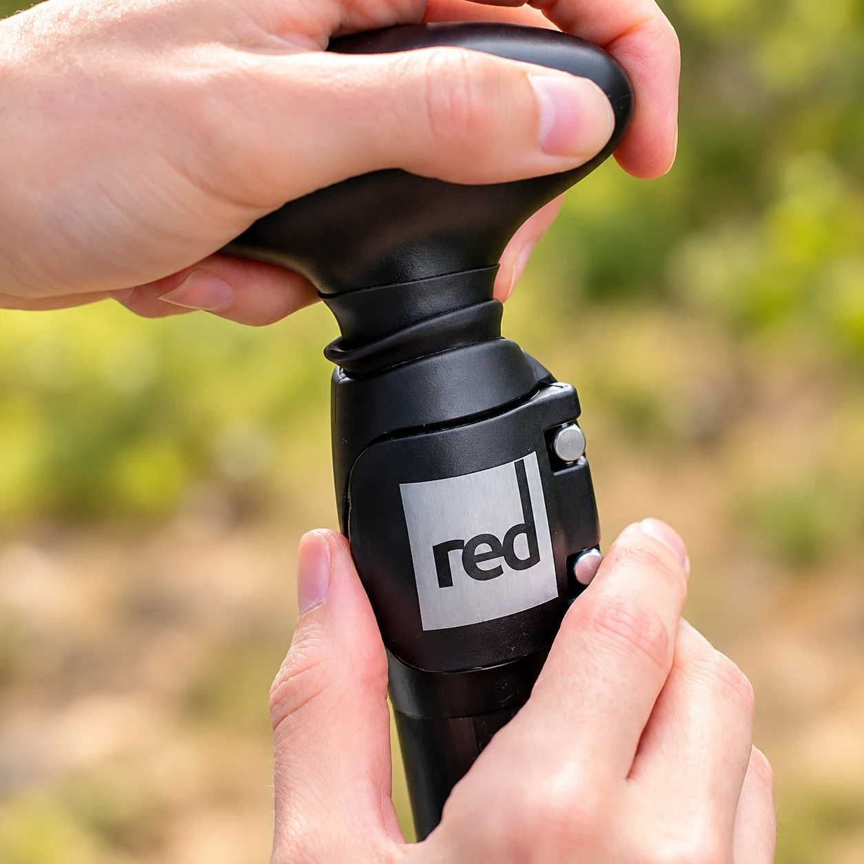 Руки проверяют рукоятку и зажим весла Red Paddle.
